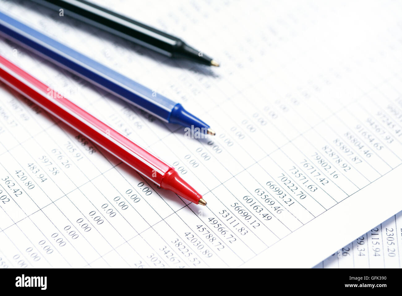 Il concetto di business. Primo piano di tre penne colorate su carta con cifre Foto Stock