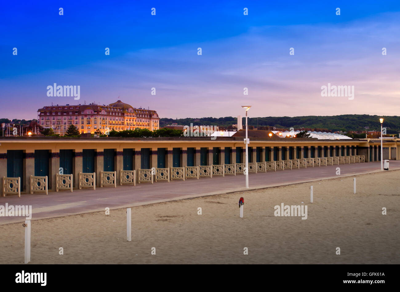 Deauville al tramonto con un vuoto di promenade des Plances e illuminato grande casinò Barrière in background Foto Stock