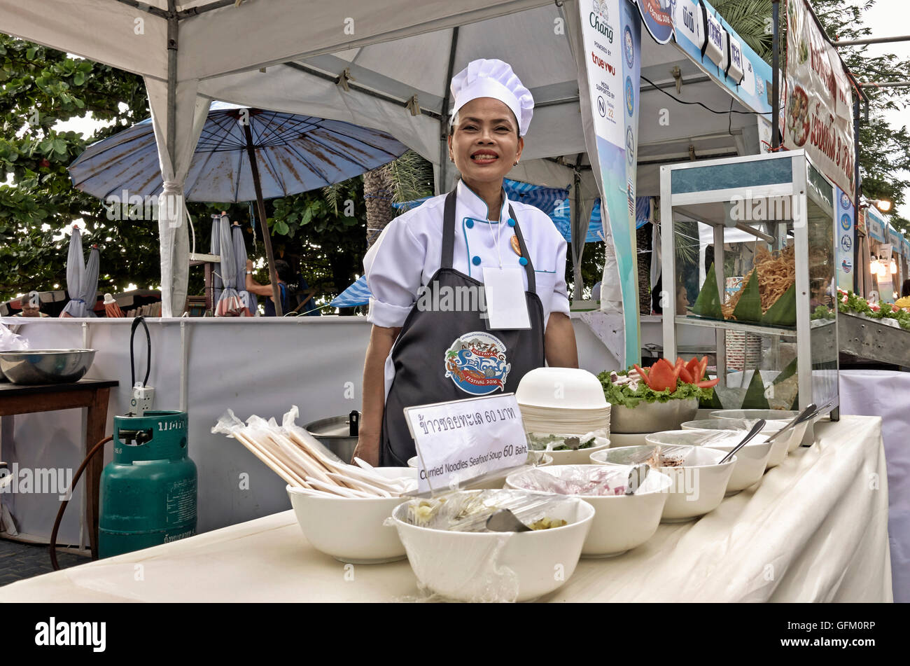 Chef femminile che serve da una stalla di cibo di strada. Thailandia S. E. Asia Foto Stock