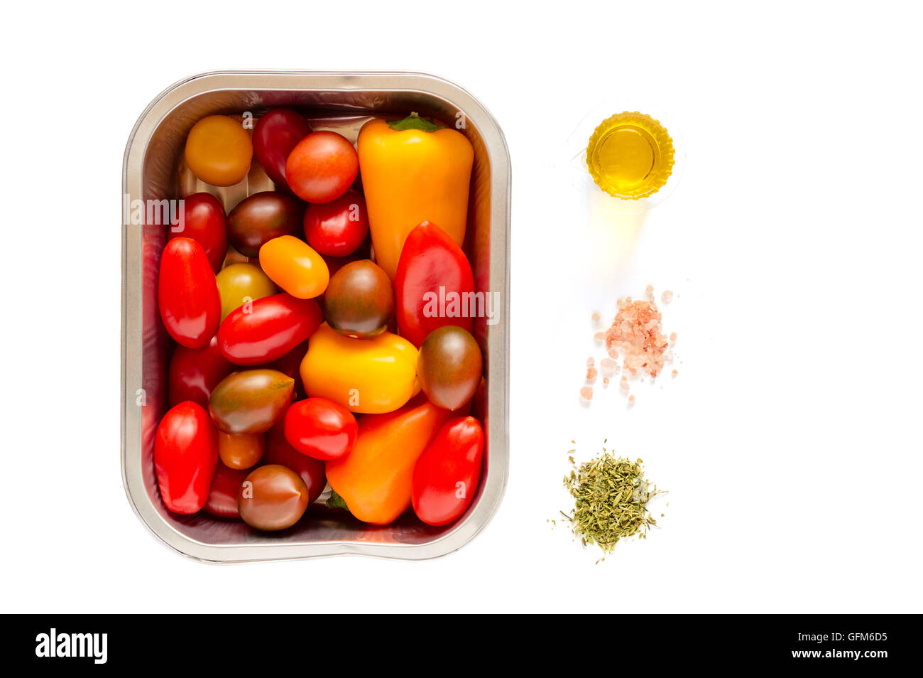 Monouso di alluminio vassoio di cottura alla griglia con un assortimento di pomodori ciliegia e piccoli peperoni pronti per la cottura Foto Stock