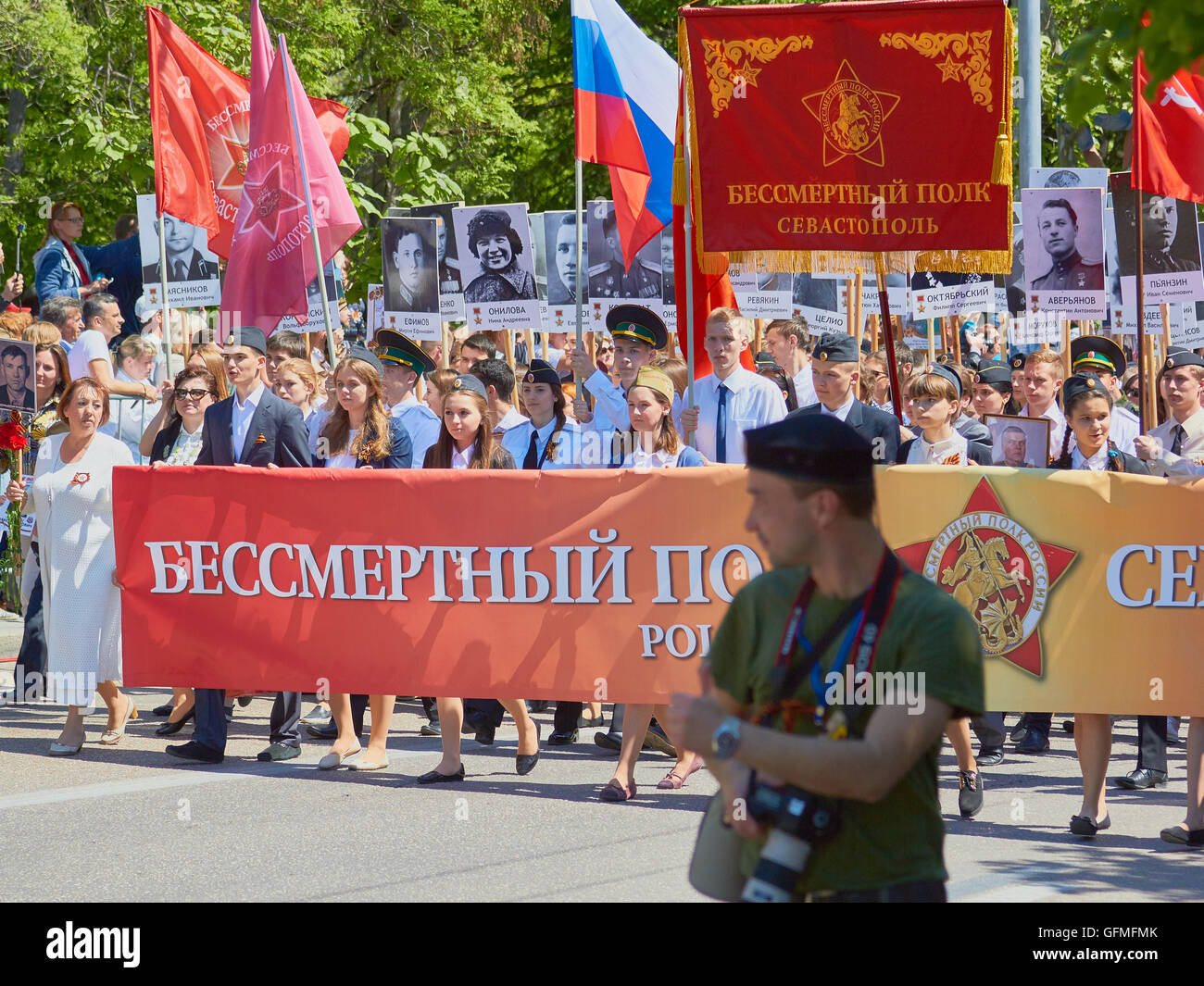 Fotografo e dimostranti che trasportano Striscioni e bandiere al 9 maggio la Giornata della Vittoria parade 2016 Sebastopoli Crimea Foto Stock