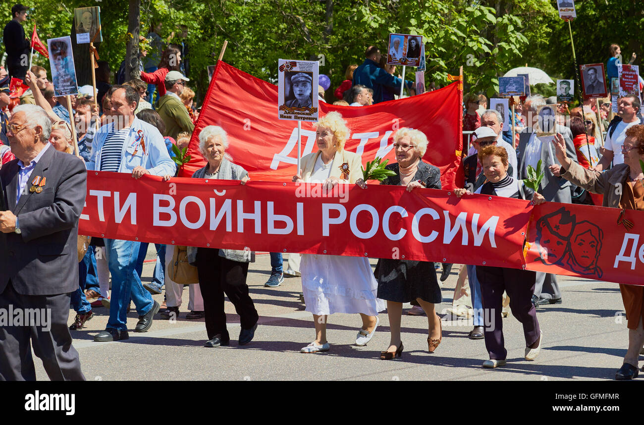 Dimostranti che trasportano un banner e fotografie durante il 9 maggio la Giornata della Vittoria parade 2016 Sebastopoli Crimea Foto Stock