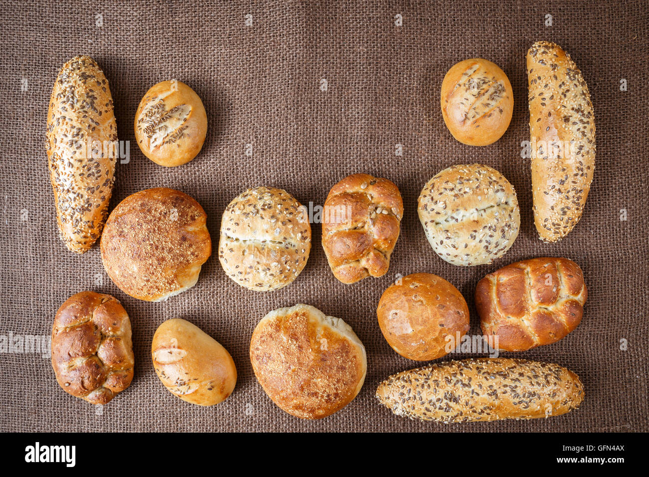 Diversi tipi di pane integrale e rotoli su sfondo marrone Foto Stock