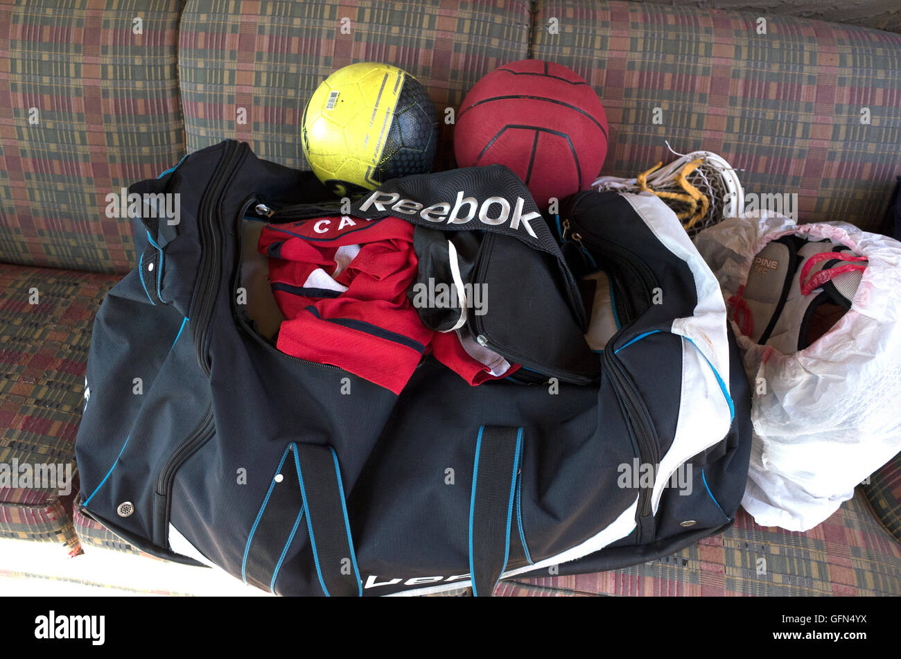 Gli adolescenti borsa sportiva con un pallone da calcio, basket,Lacrosse stick testa, uniforme e pastiglie. St Paul Minnesota MN USA Foto Stock