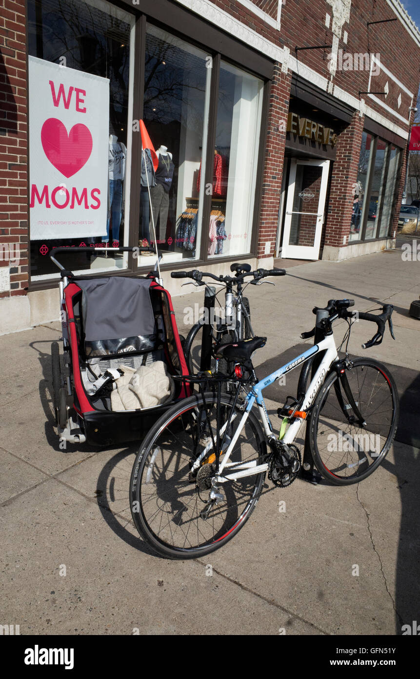 Bicicletta e il bambino al di fuori del rimorchio Evereve donna negozio di abbigliamento, promozione di abiti firmati per mamme. St Paul Minnesota MN USA Foto Stock