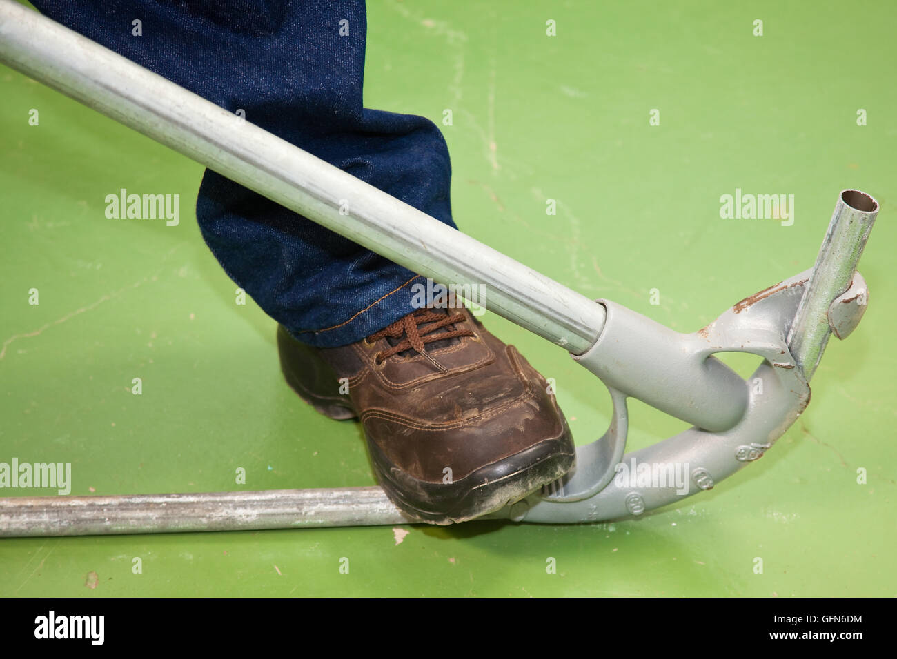 La curvatura di un tubo utilizzando un attrezzo speciale Foto Stock