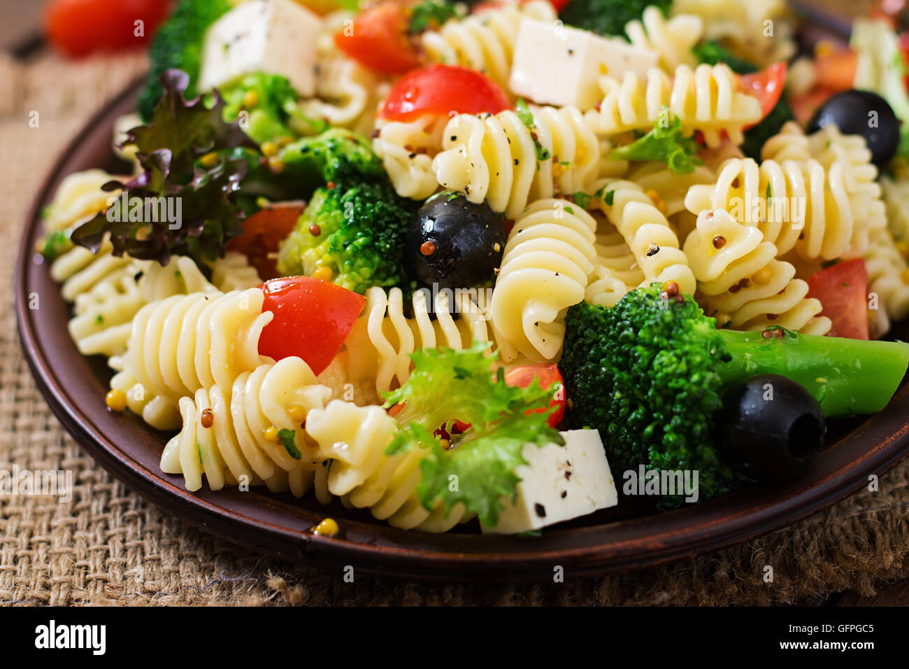 Insalata di pasta con pomodoro, broccoli, olive nere e formaggio feta Foto Stock
