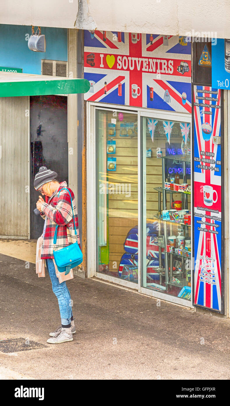 Persona in piedi nella parte anteriore del negozio di souvenir shop a Bournemouth in luglio Foto Stock