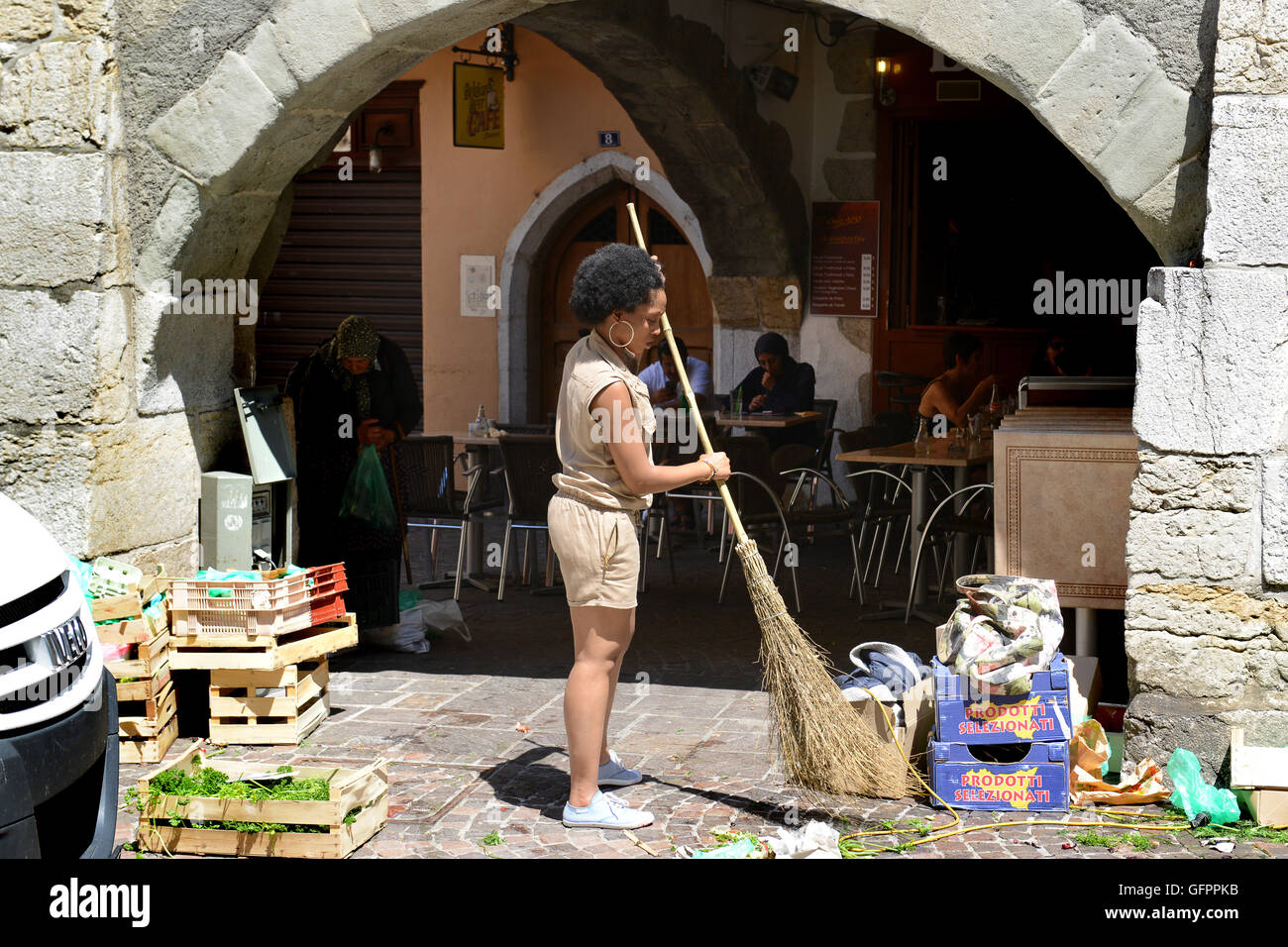 Donna mercato titolare di stallo di spazzamento stradale pulizia eliminazione rifiuti rifiuti a Annecy in Francia Foto Stock