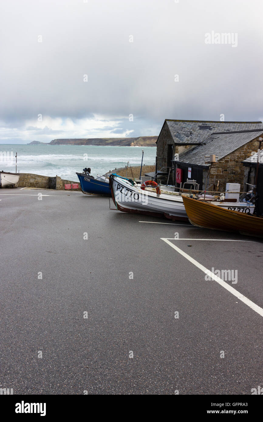 Per la pesca costiera di bolina barche fino in auto e barca park a Sennen Cove, Cornwall, Regno Unito. Cape Cornwall in distanza. Foto Stock
