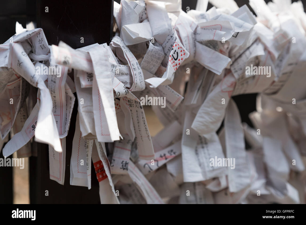 Piccoli fogli di carta con la preghiera personale e di memorie attaccato ad una griglia di metallo nella parte anteriore di un tempio Shintoista a Tokyo Giappone Foto Stock