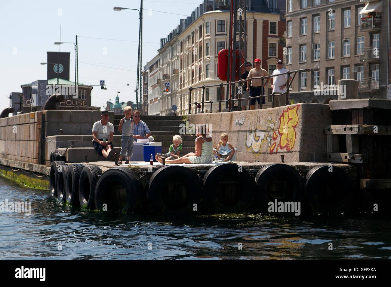 Famiglia avente picnic al waterfront - Nyhavn, Copenhagen, Danimarca Foto Stock