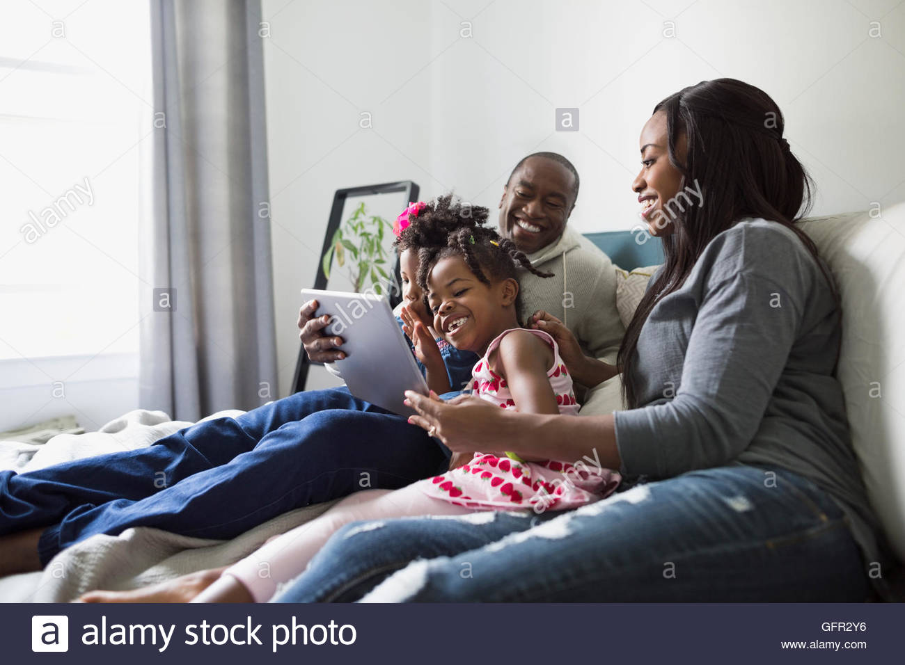 Famiglia giovane con tavoletta digitale Foto Stock