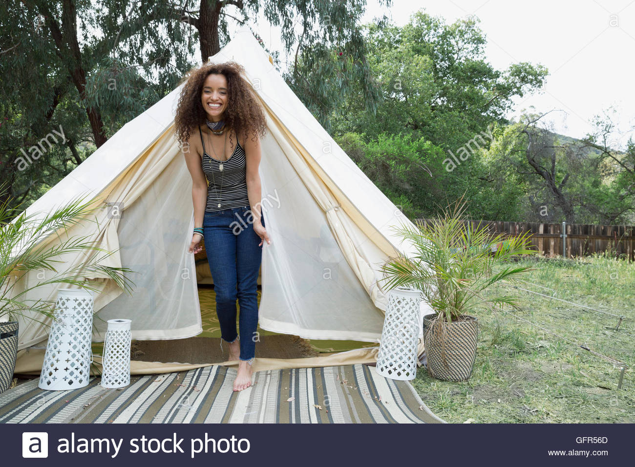 Ritratto sorridente giovane donna in camping yurt porta Foto Stock