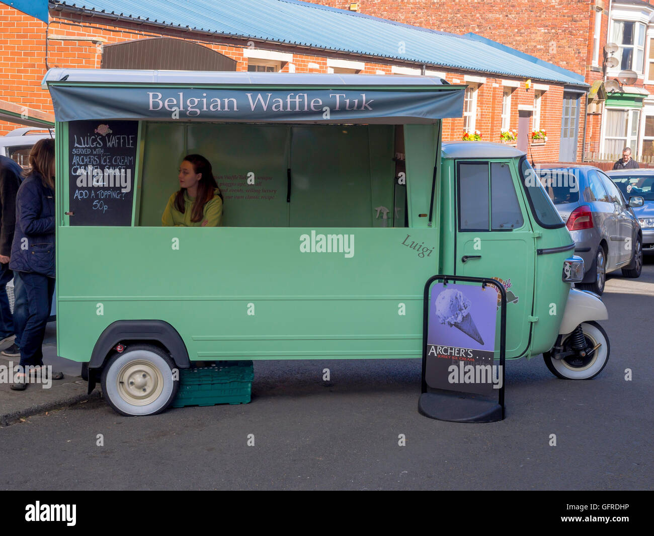 L annuale Saltburn Food Festival una donna in Piaggio Vespa a tre ruote Tuk vendita cialde belghe Foto Stock