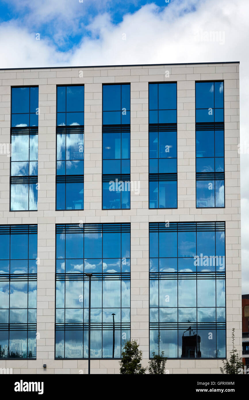Ufficio moderno blocco con cielo blu riflessa nel buio windows Foto Stock
