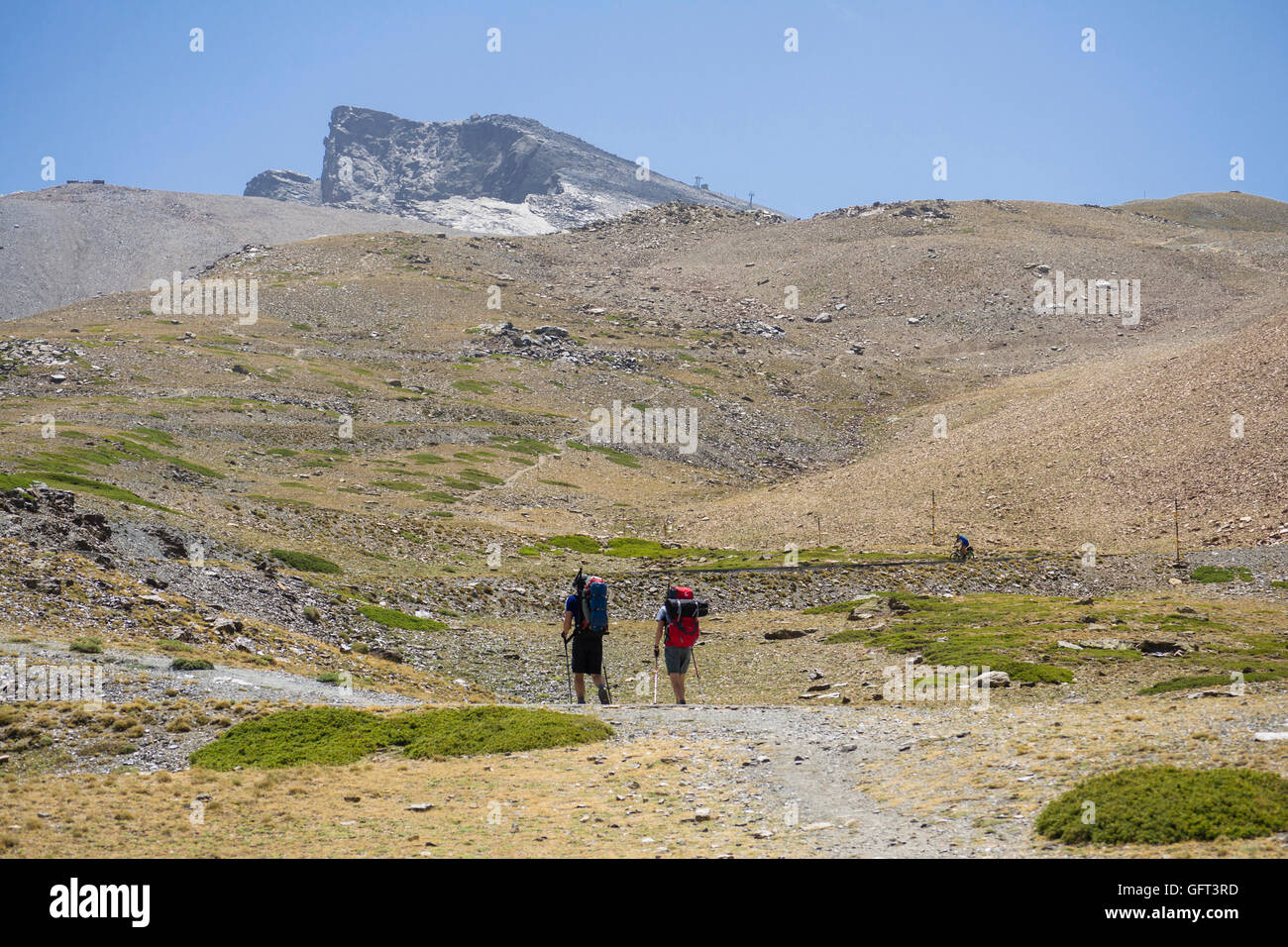 Due escursionisti seguendo il sentiero per Pico del vertice Valeta, Sierra Nevada, nella stagione estiva. Granada, Andalusia, Spagna. Foto Stock