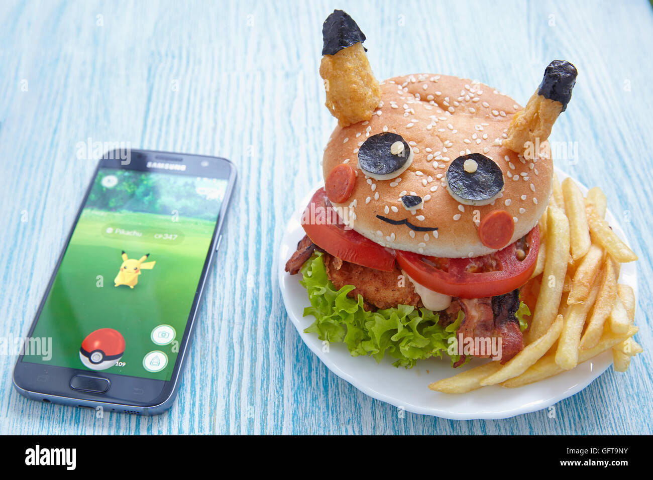 Mosca, Russia - 29 luglio 2016 Editorial immagine: Fan Art Pikachu Burger e Smartphone con Pokemon Go. Foc selettiva Foto Stock