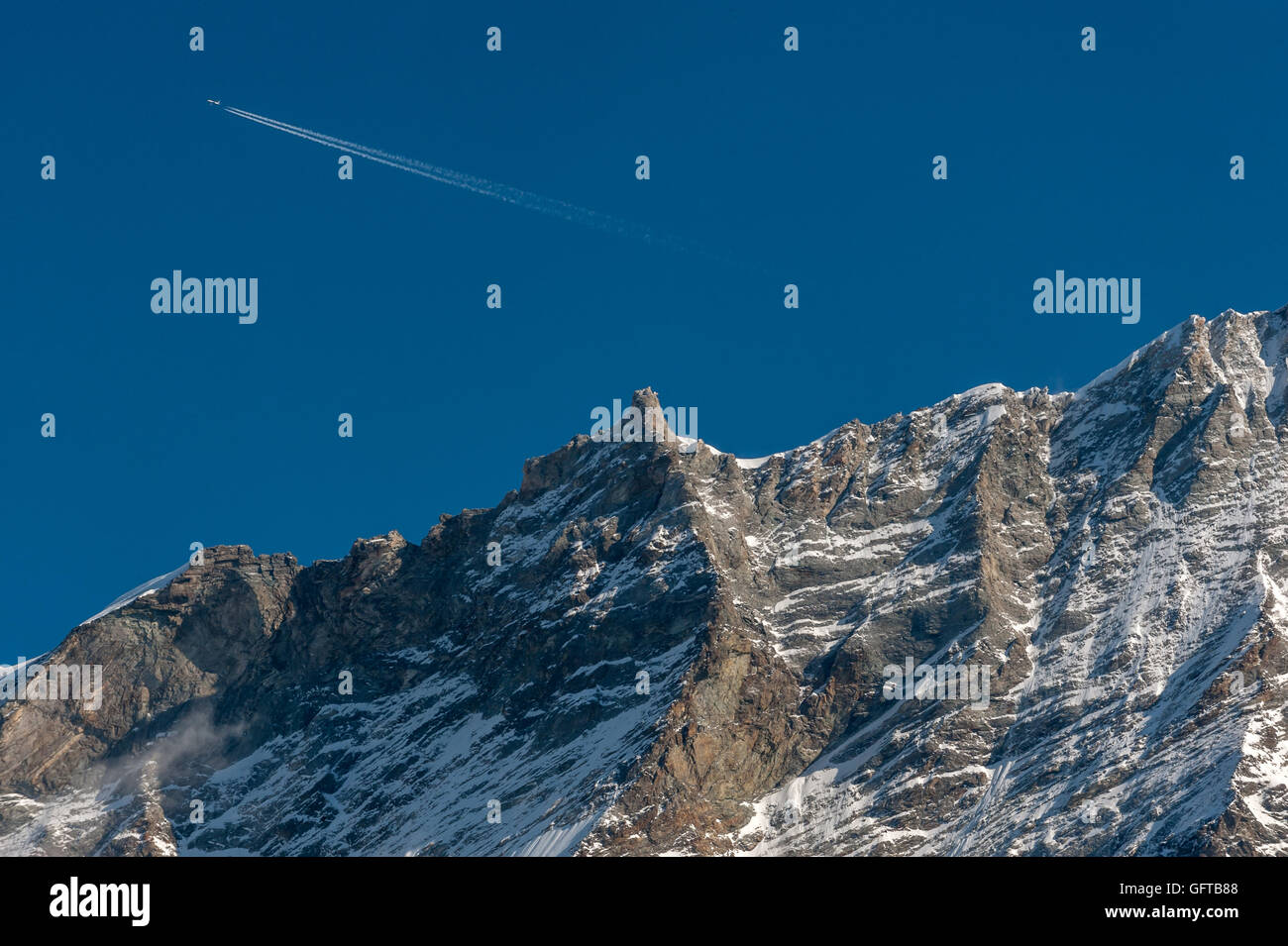 Un aereo sorvola le alte montagne delle Alpi svizzere, vicino a St Luc nel Cantone del Vallese. Foto Stock