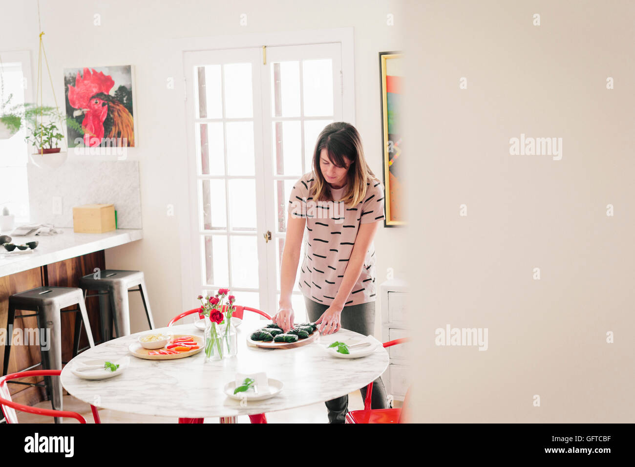 Una donna che stabilisce un tavolo per il pranzo Foto Stock