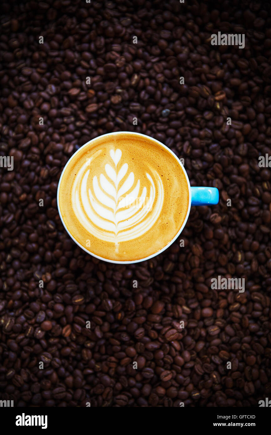 Vista da sopra di una tazza di caffè con un complesso abbastanza foglia di felce pattern in schiuma Foto Stock