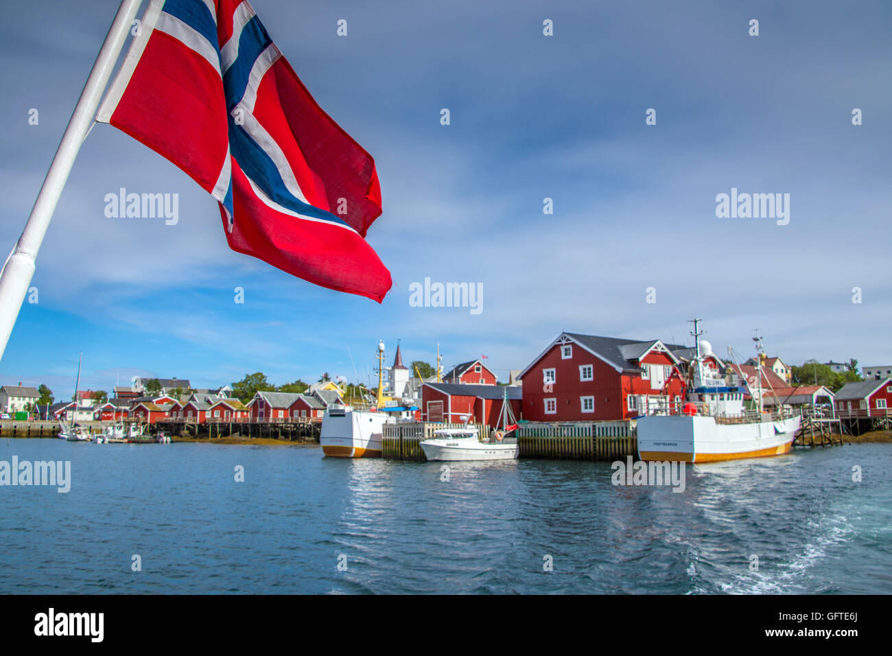Bandiera norvegese con Red Rorbu e barche da pesca, la Reine, Isole Lofoten artico, Norvegia, Scandinavia, Europa Foto Stock