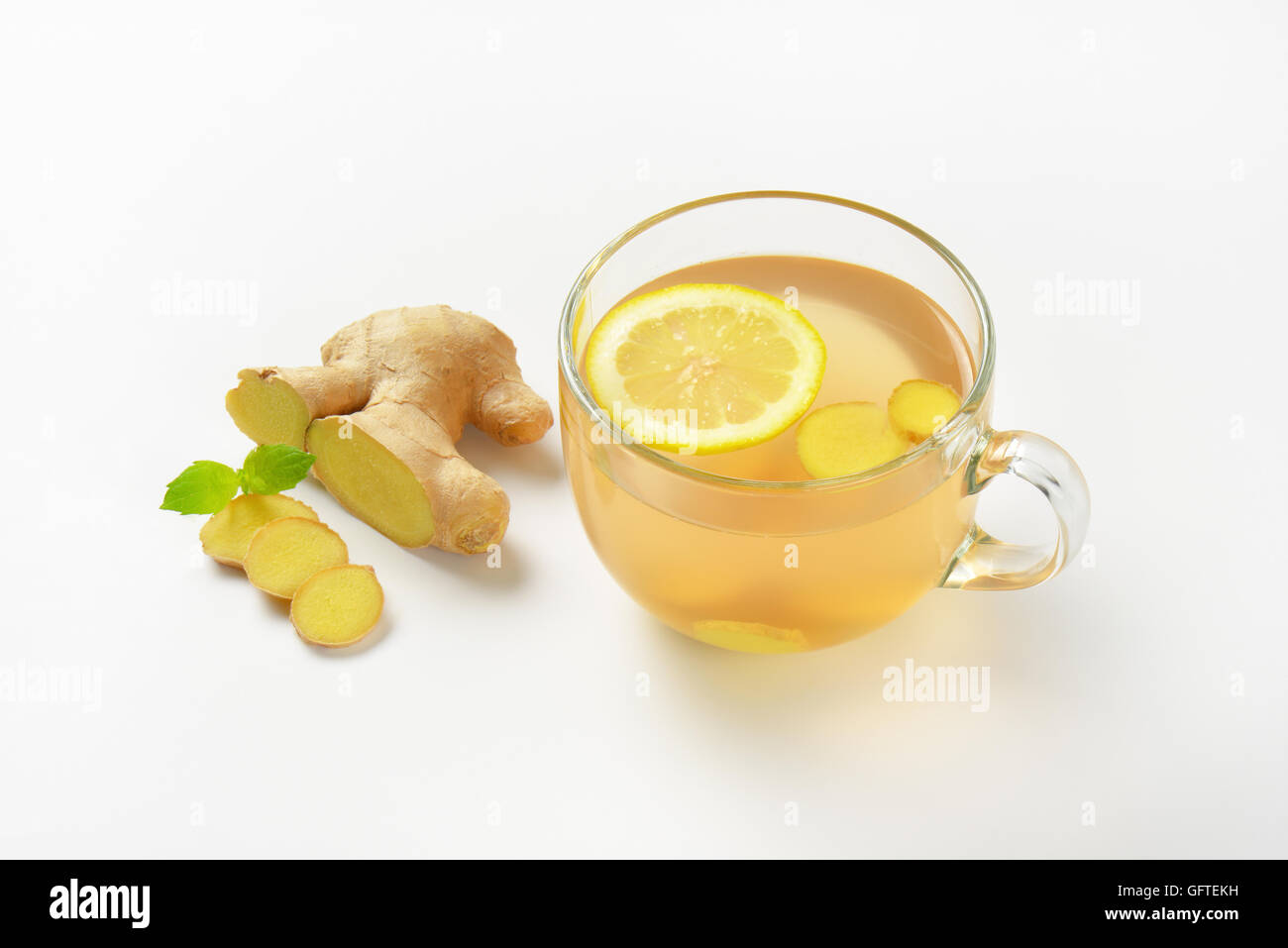 Tazza di tè allo zenzero con limone e zenzero fresco su sfondo bianco Foto Stock
