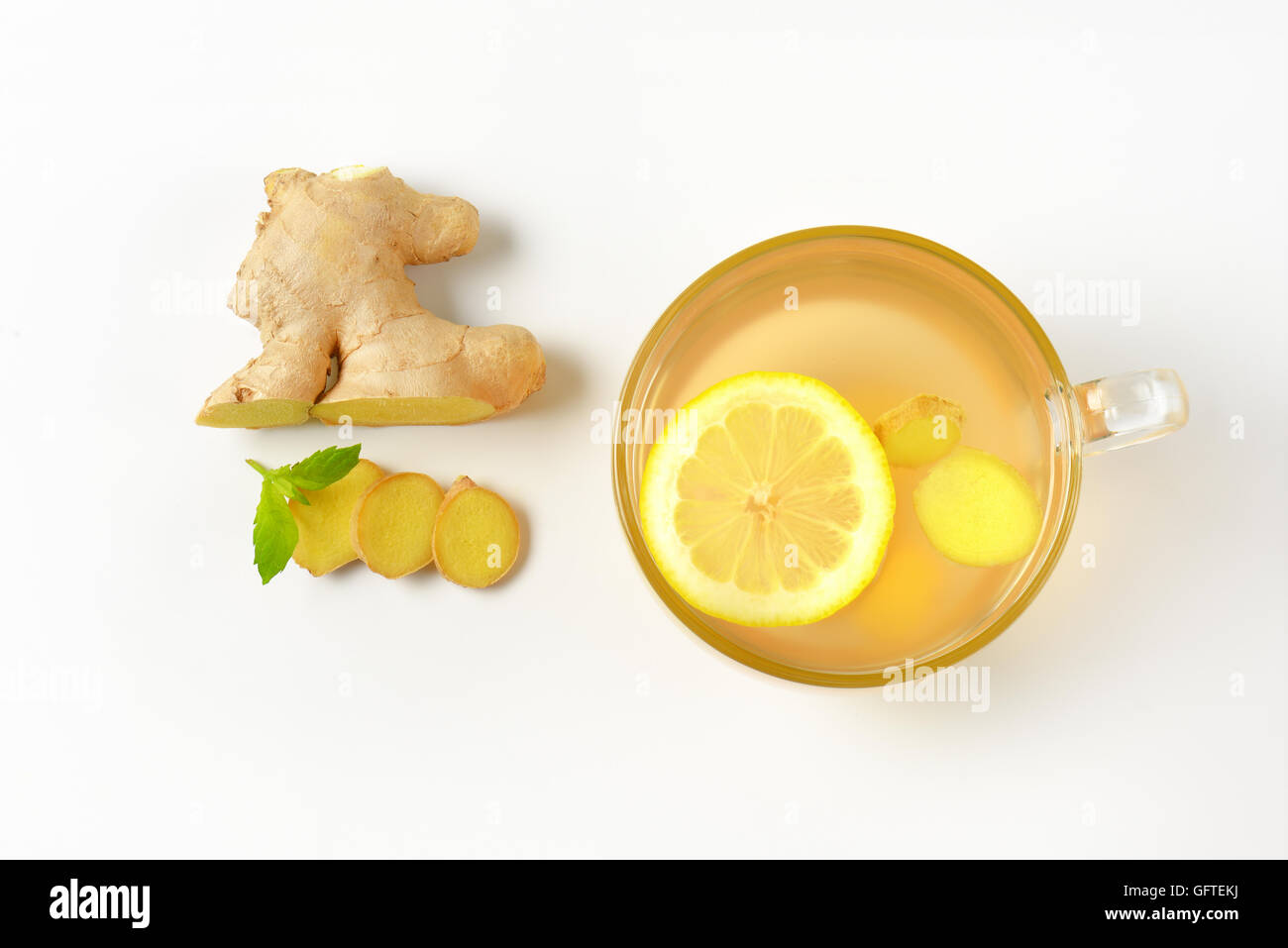 Tazza di tè allo zenzero con limone e zenzero fresco su sfondo bianco Foto Stock