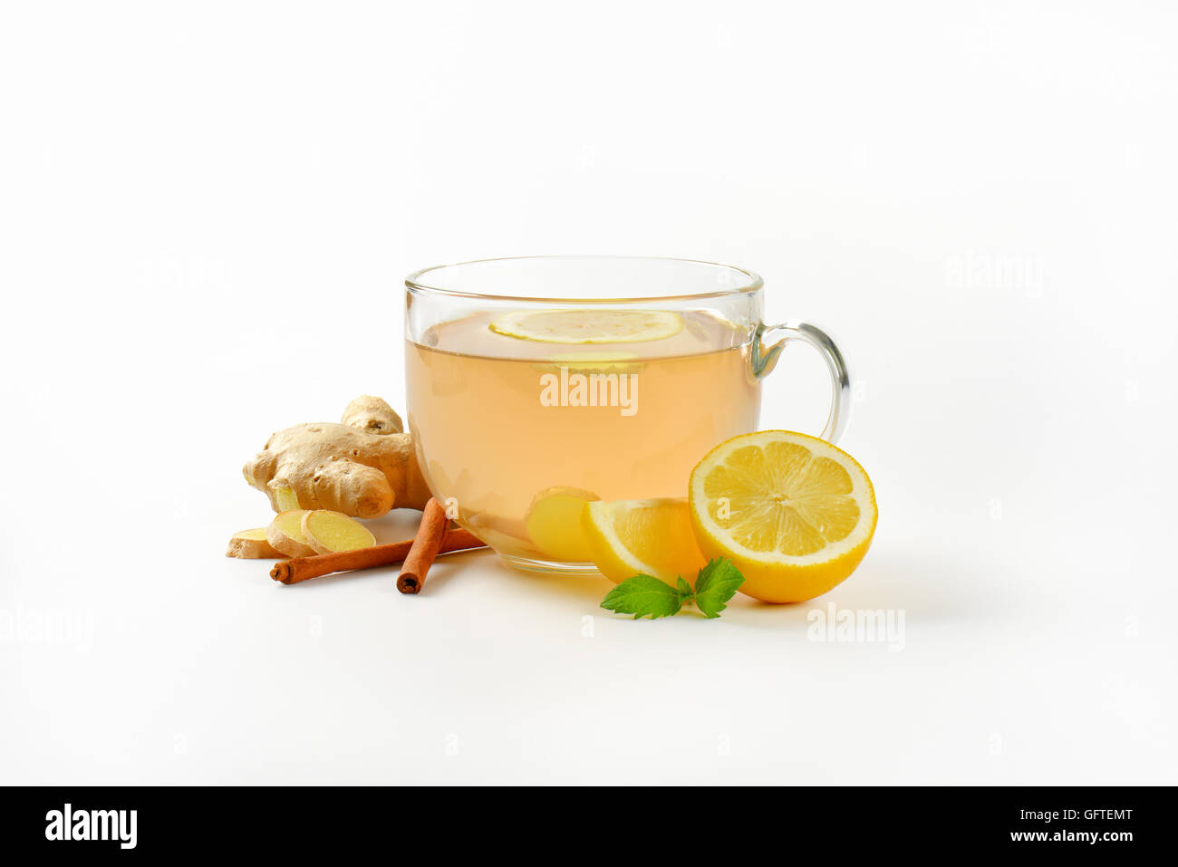 Tazza di tè allo zenzero con succo di limone, lo zenzero fresco e cannella su sfondo bianco Foto Stock