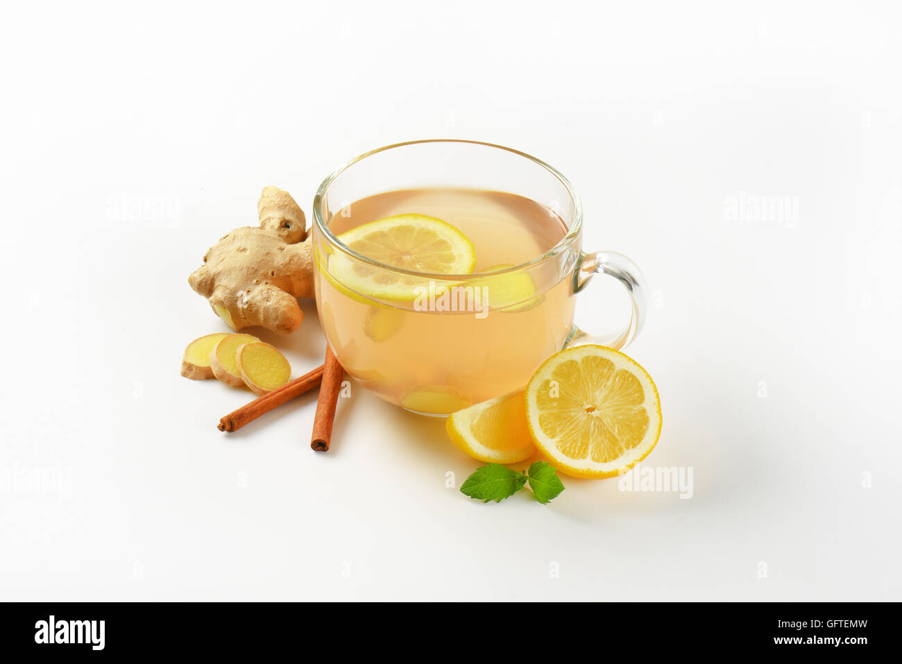 Tazza di tè allo zenzero con succo di limone, lo zenzero fresco e cannella su sfondo bianco Foto Stock