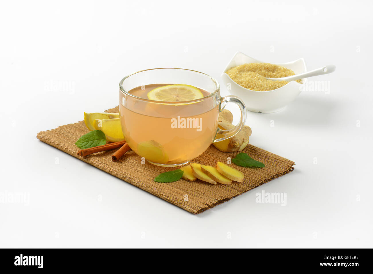 Tazza di tè allo zenzero con succo di limone, lo zenzero fresco e cannella sul tagliere di legno Foto Stock