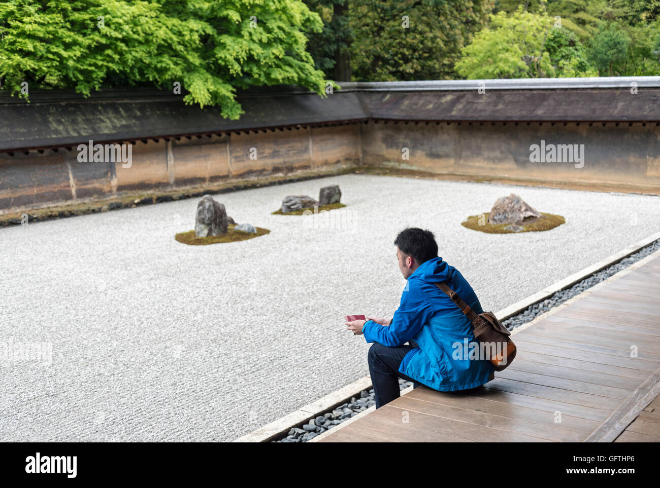 Giovane uomo contempla al Rock giardino zen, (Ryoanji Ryoan-ji Tempio), Kyoto, Giappone Foto Stock