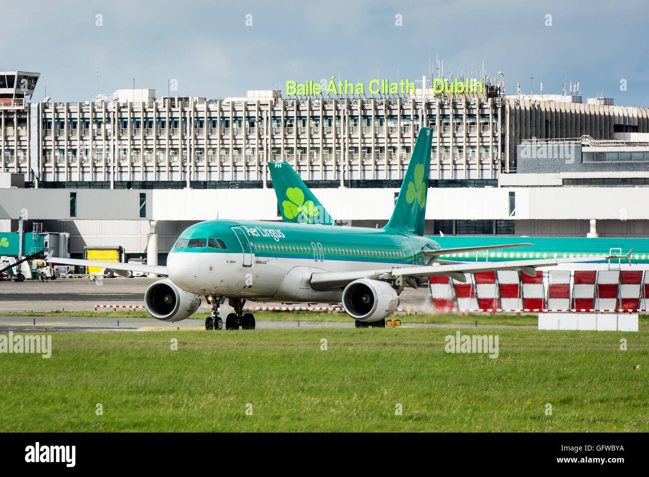 Aer Lingus piano su terreno presso l'aeroporto di Dublino con aeroporto di Dublino segno sul terminale dietro Foto Stock