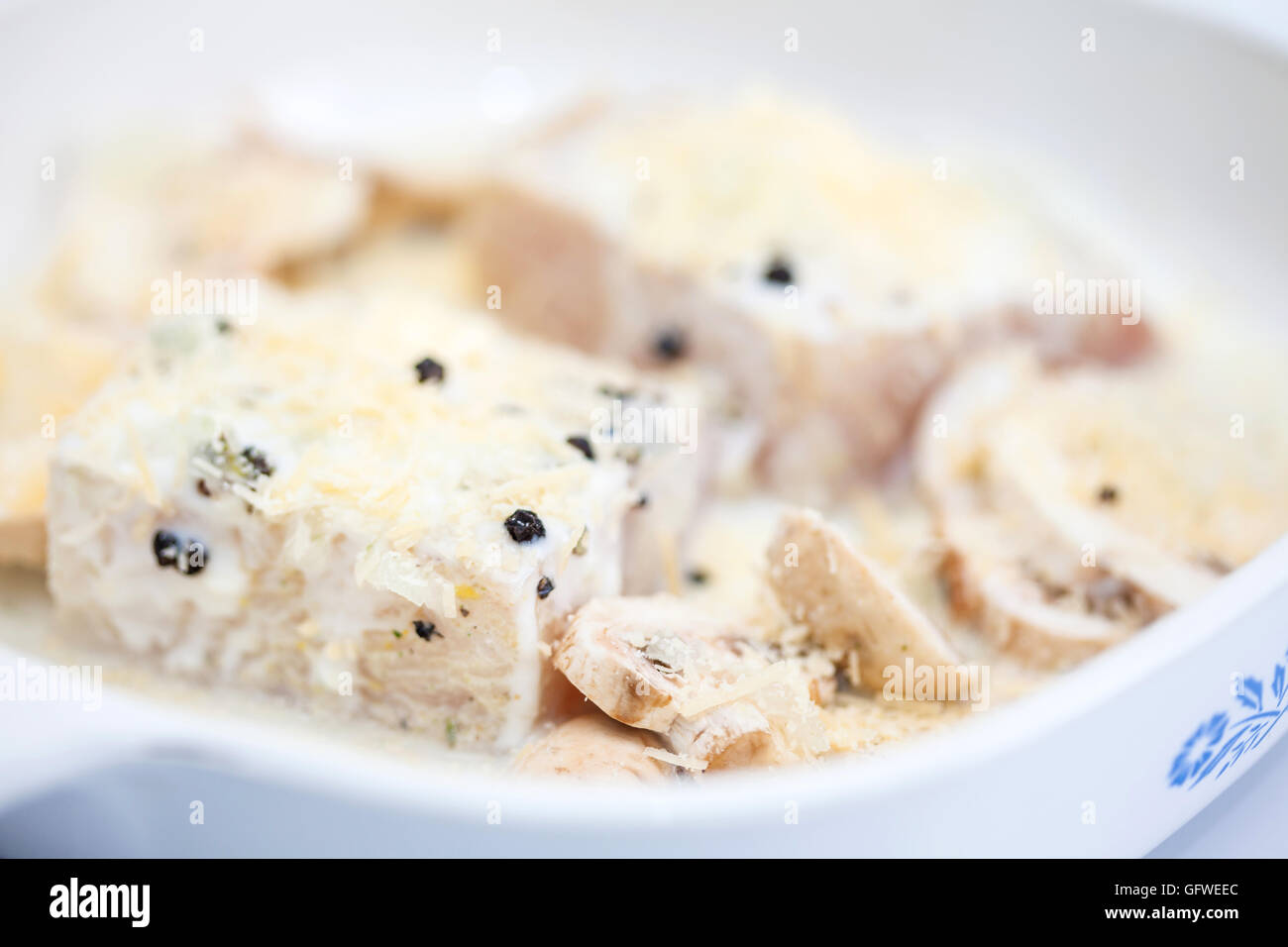 Crudo marinato filetto di branzino con funghi in una teglia da forno Foto Stock