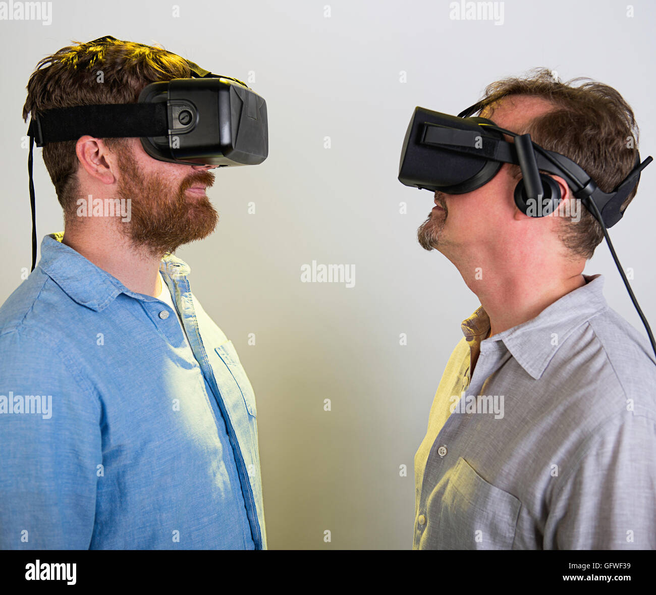 Due uomini con l'occhio Rift VR cuffie, versione 2 e 3. Foto Stock