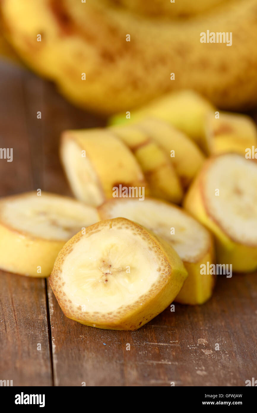 Primo piano di un trito di banane mature su una superficie in legno Foto Stock