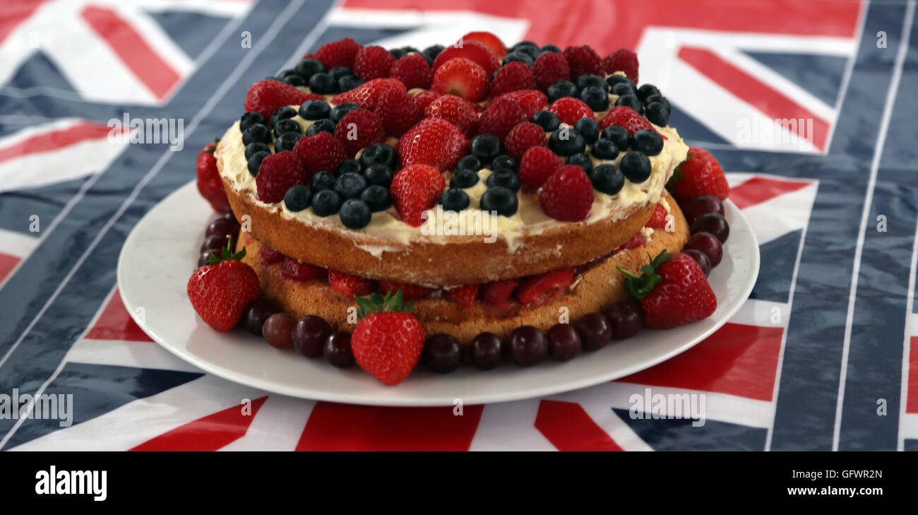 Street partito svoltasi nella celebrazione della Regina Elisabetta II il novantesimo compleanno - Union Jack con torta di fragole, mirtilli e uva Cornwall Road Surrey in Inghilterra Foto Stock