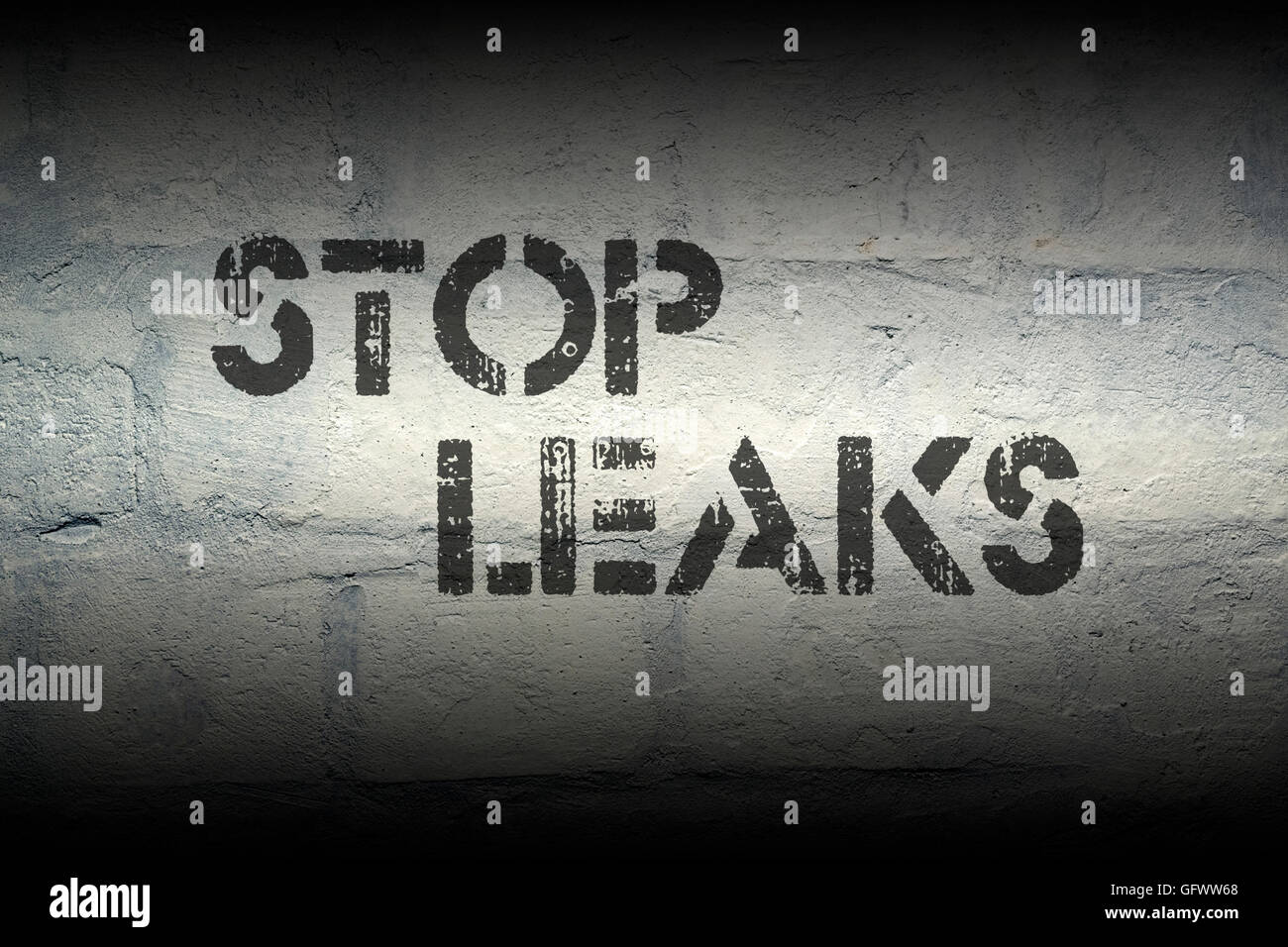 Perdite di arresto stencil sulla stampa del grunge bianco muro di mattoni Foto Stock