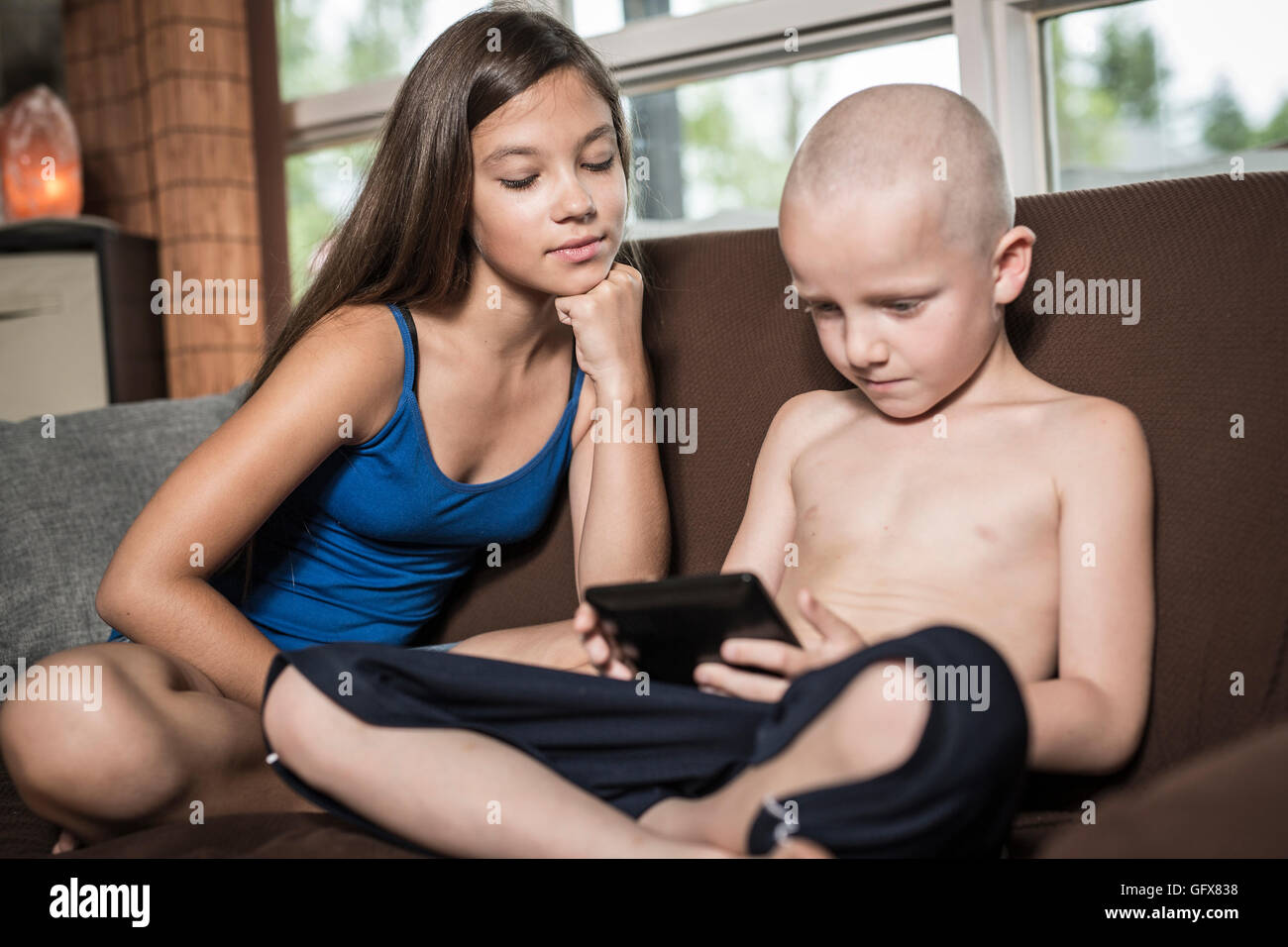 Servizio di baby sitter con un bambino divano techno Foto Stock