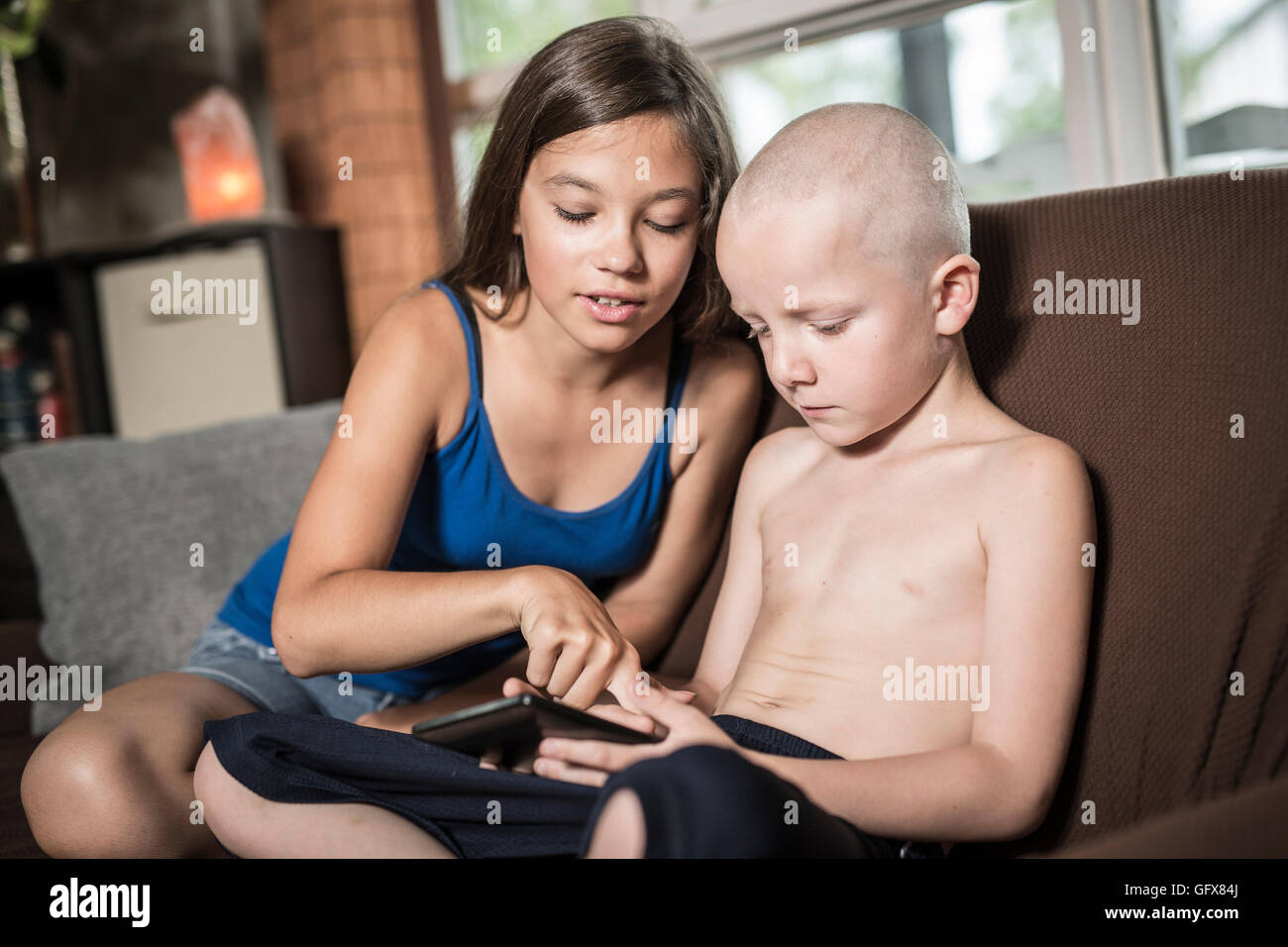 Servizio di baby sitter con un bambino divano techno Foto Stock