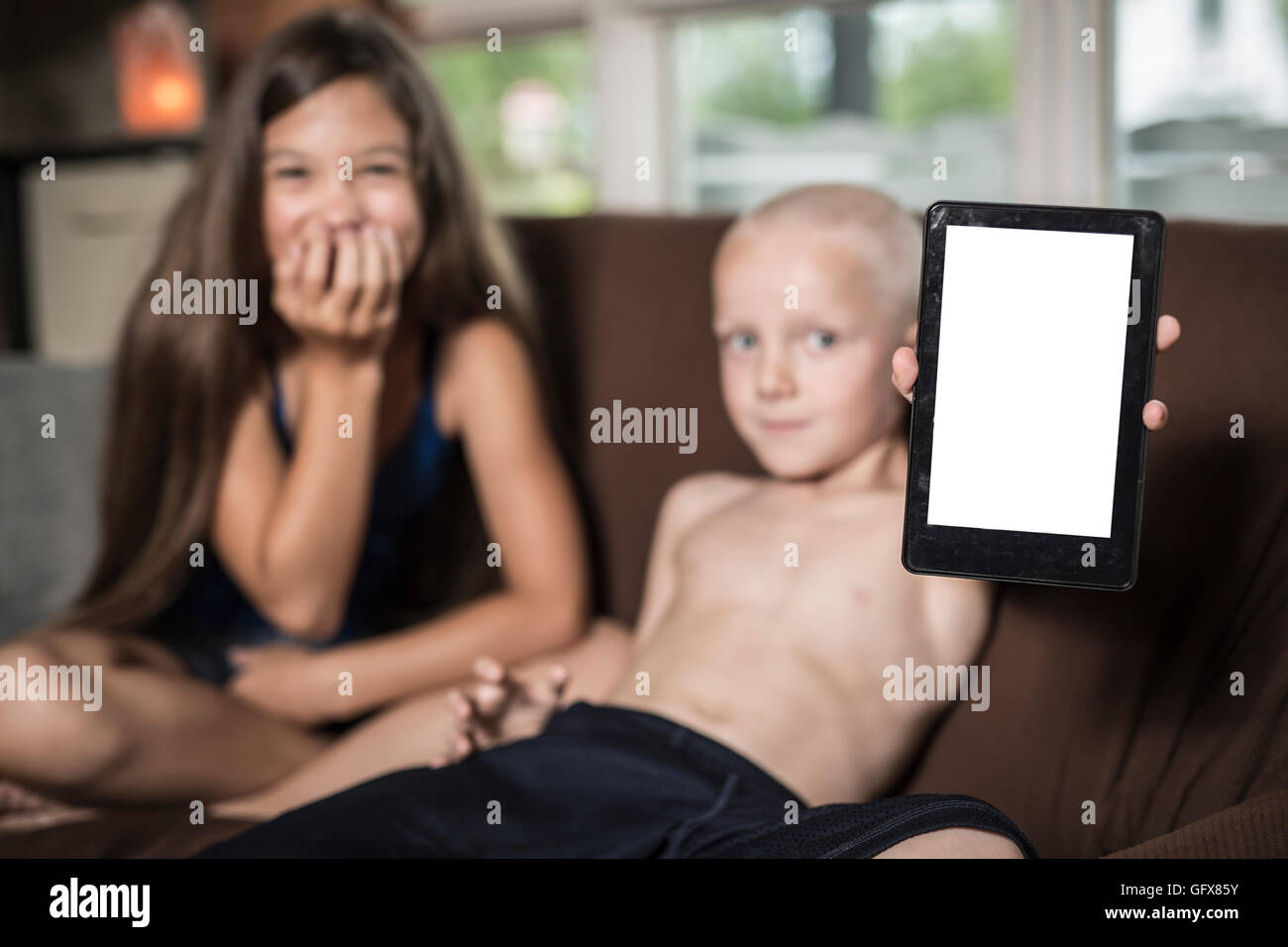 Servizio di baby sitter con un bambino divano techno Foto Stock