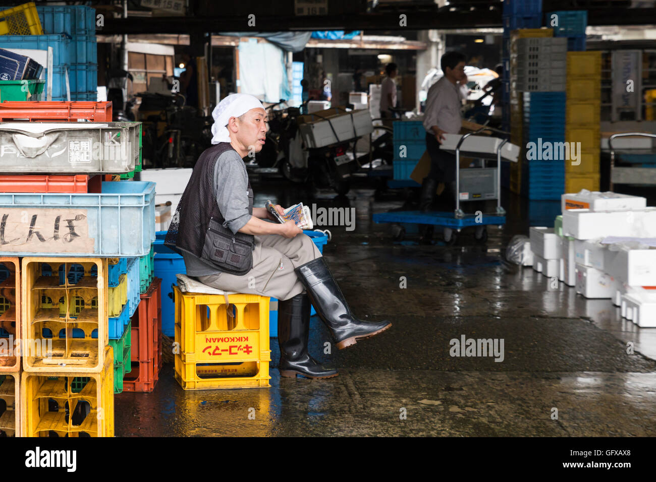 Un lavoratore sta avendo una pausa e leggere il giornale al mercato del pesce Tsukiji a Tokyo in Giappone Foto Stock