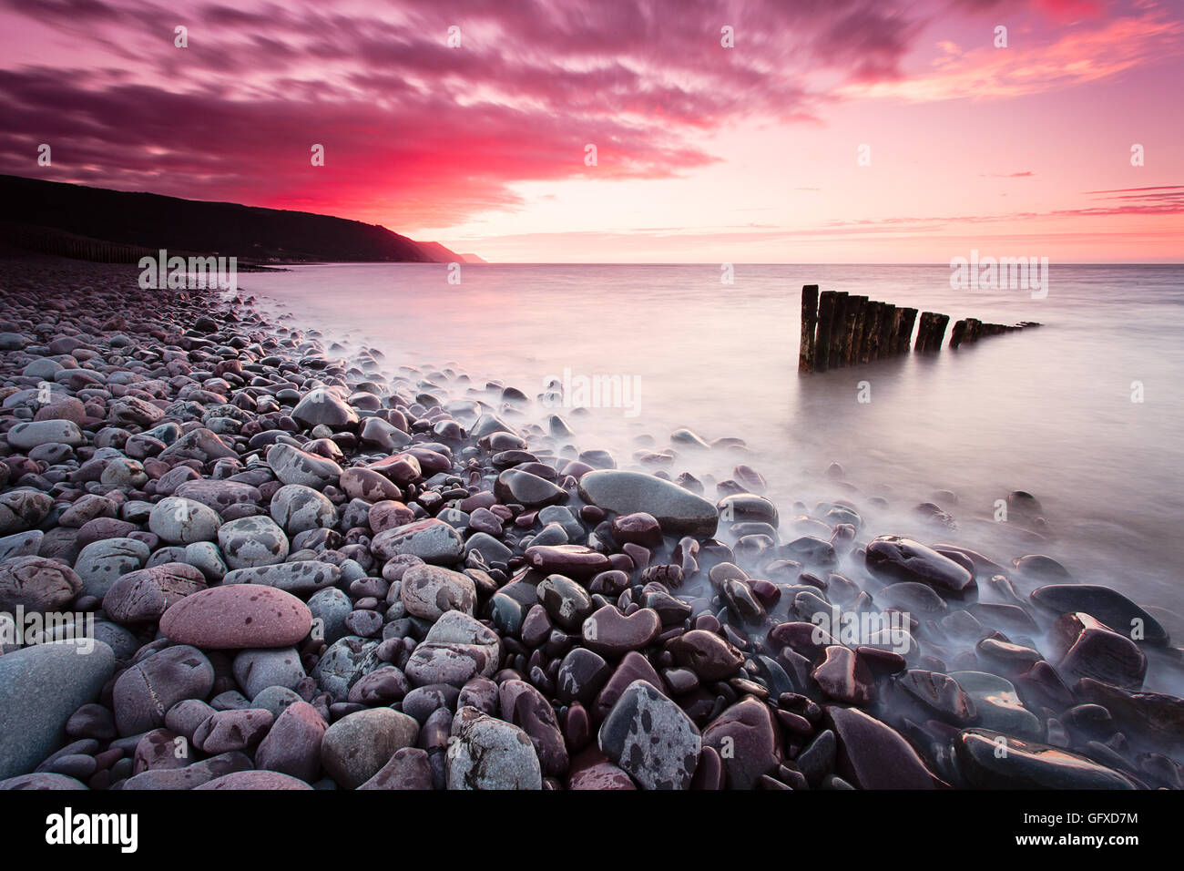 Tramonto a Bossington Beach, guardando i vecchi pennelli rimanente nell'acqua. Vista su Porlock Weir in North Somerset Foto Stock