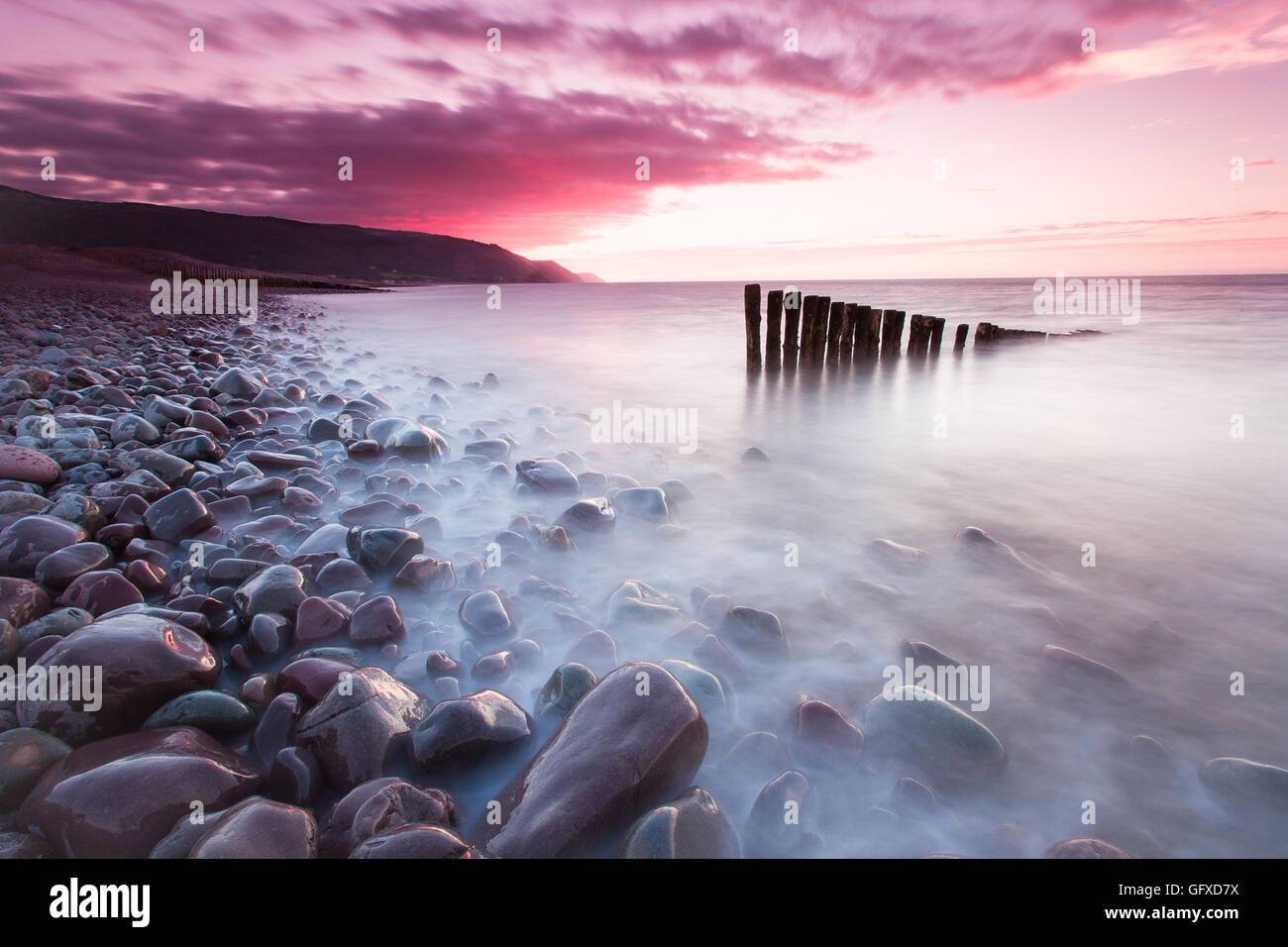 Tramonto a Bossington Beach, guardando i vecchi pennelli rimanente nell'acqua. Vista su Porlock Weir in North Somerset Foto Stock