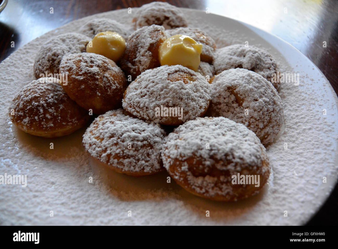 Poffertjes servita con zucchero a velo e il burro, un tradizionale dessert olandese di mini pancake che sono fatti con il lievito e grano saraceno Foto Stock