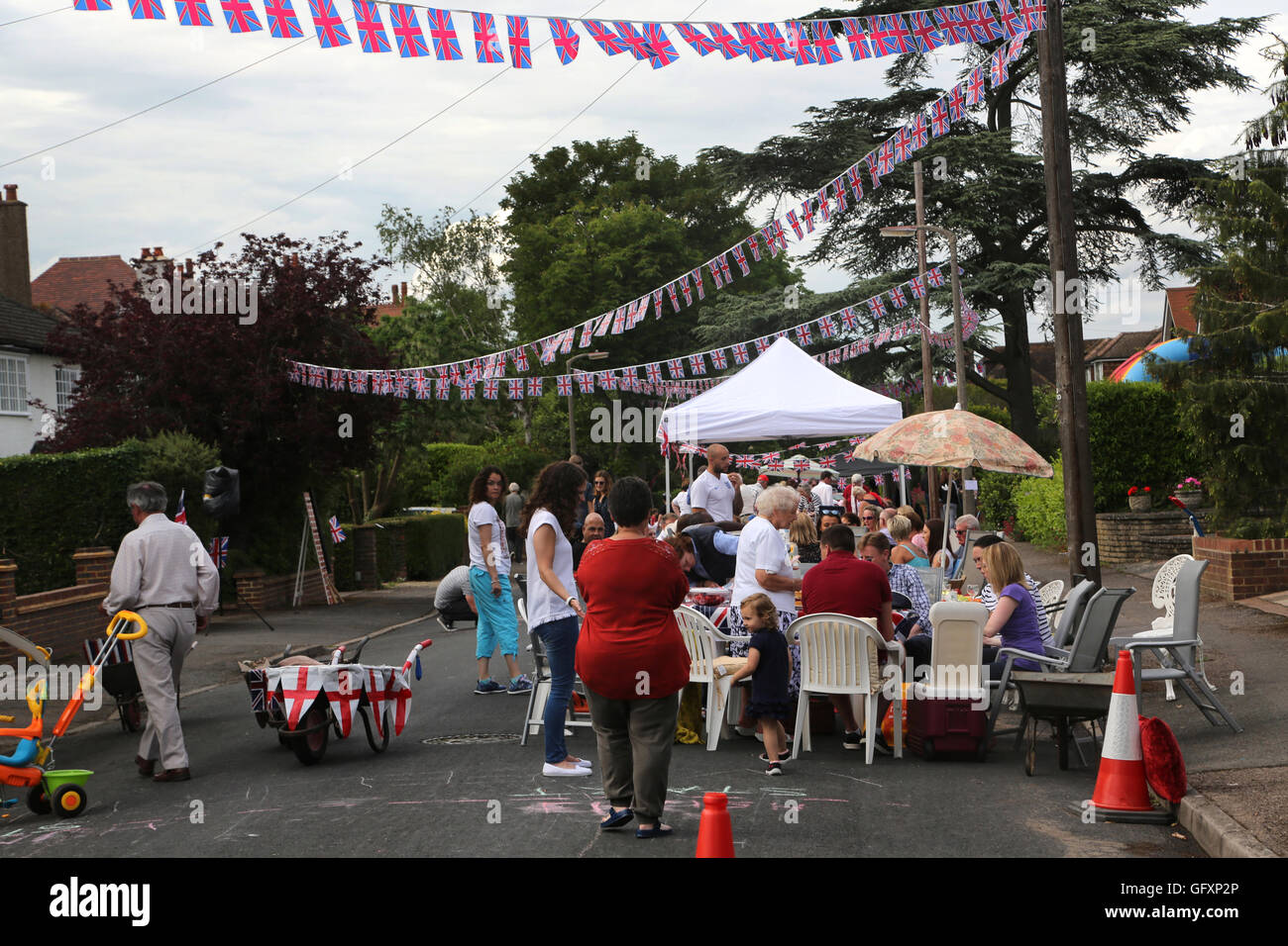 Street partito svoltasi nella celebrazione della Regina Elisabetta II il novantesimo compleanno - persone mangiare seduti ai tavoli Cornwall Road Surrey Engl Foto Stock