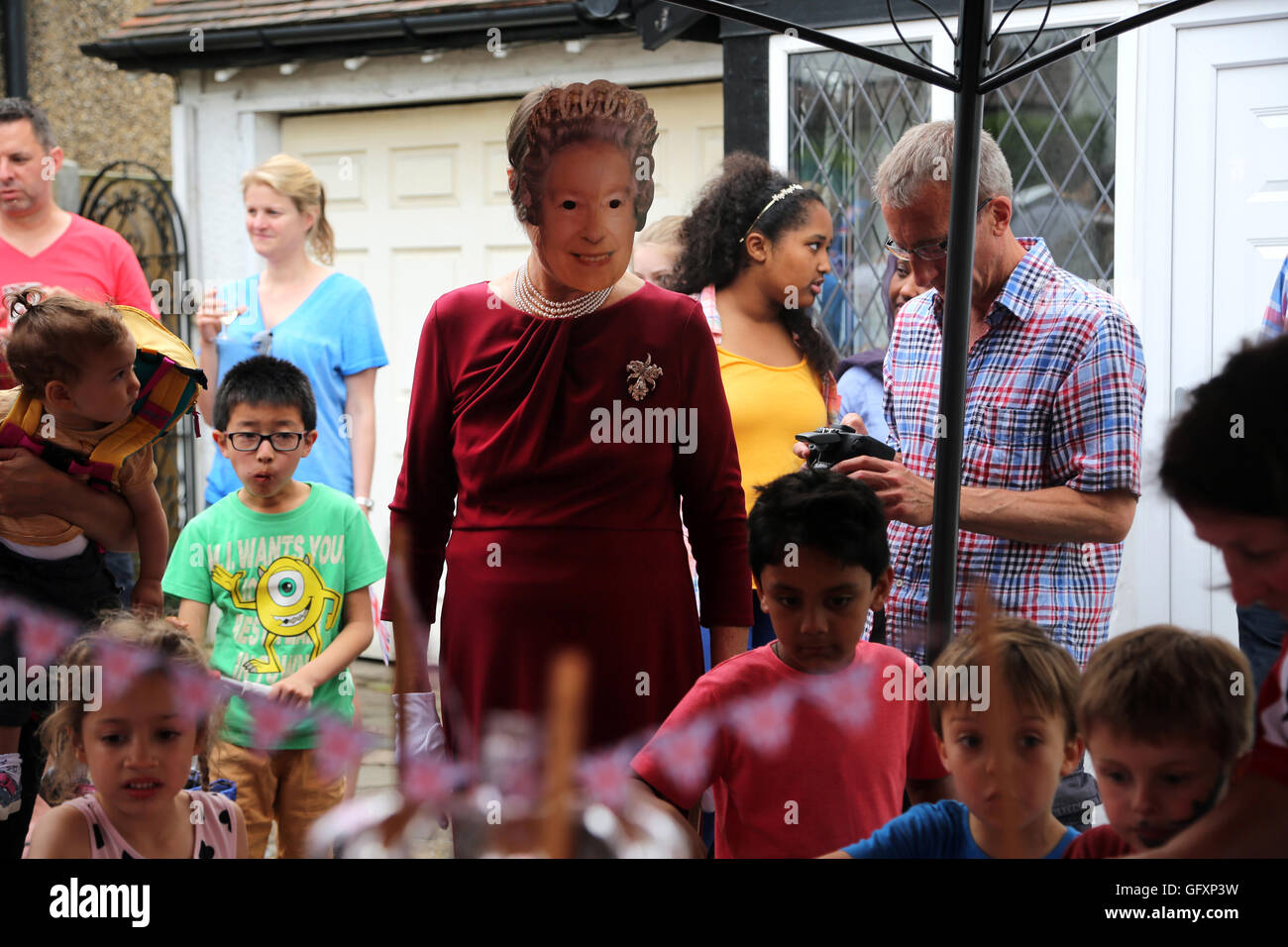 Street partito svoltasi nella celebrazione della Regina Elisabetta II il novantesimo compleanno - donna che indossa una maschera e vestita come la regina della Cornovaglia Ro Foto Stock