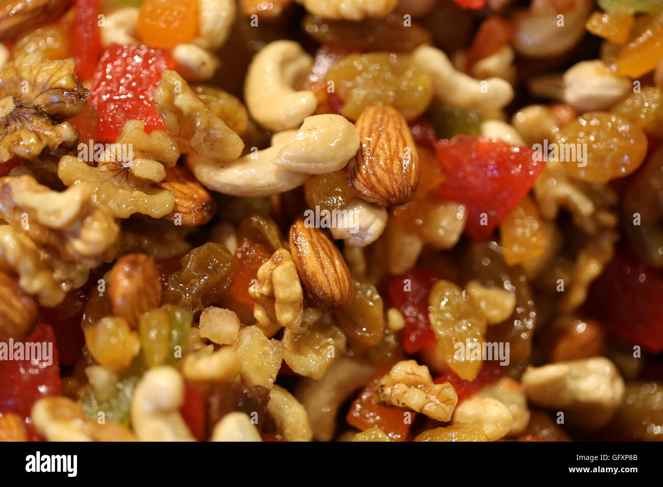 La frutta candita e la frutta disidratata, vicino. Pila di frutti cristallizzato: anacardi, noci, mandorle, uva passa, papaia, mango e kiwi. Foto Stock