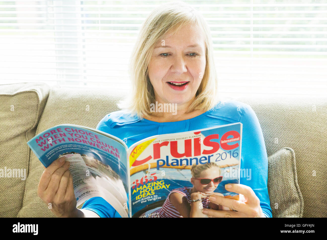 La donna la lettura di vacanza in crociera magazine brochure Foto Stock
