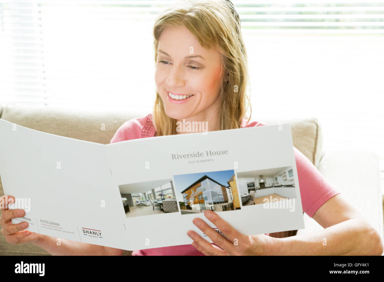 La donna la lettura di un agente immobiliare della brochure Foto Stock
